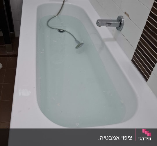 אמבטיה עם מים, ברז וכיסוי קיר חום-לבן